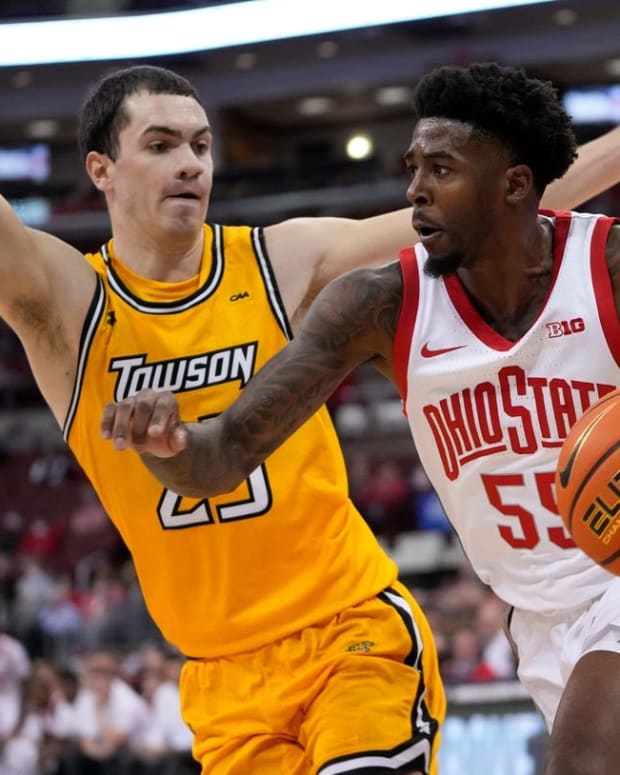Ohio State Buckeyes guard Jamari Wheeler (55) dribbles around Towson Tigers guard Nicolas Timberlake (25) during the first half of the NCAA men's basketball game at Value City Arena in Columbus on Wednesday, Dec. 8, 2021.

Towson Tigers At Ohio State Buckeyes Basketball